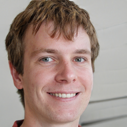 Portrait d'un homme souriant dans un environnement de bureau lumineux.